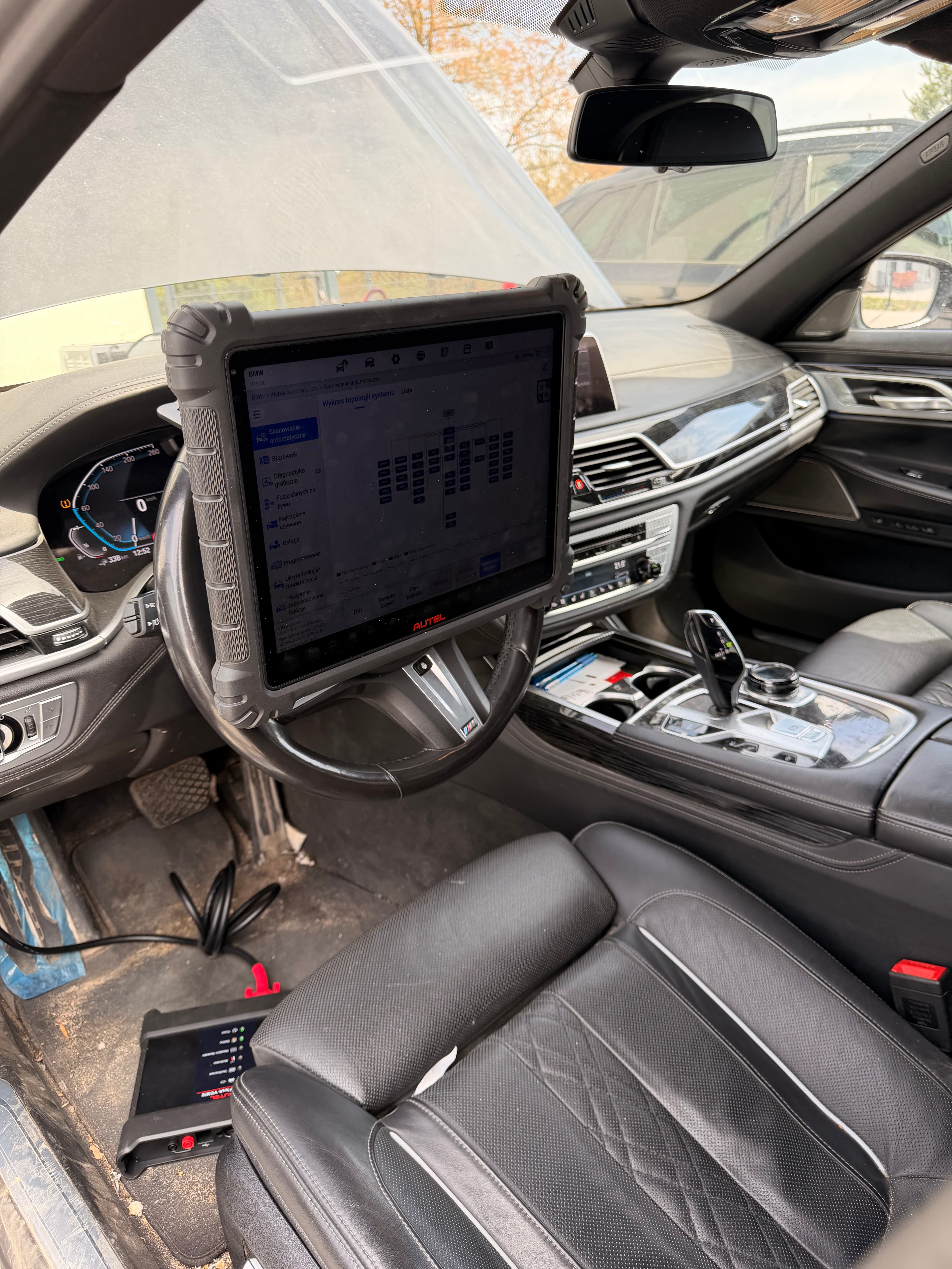 Tablet Autel MaxiSYS Ultra S2 na kierownicy BMW 745Le z listą wyników autoscanu — sesja 1 diagnostyki